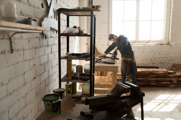 Fabricante de gabinetes calificado trabajando en un pequeño taller
 - Foto, Imagen