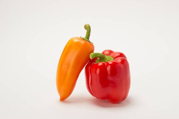 Twee mooie rode paprika's op een witte achtergrond - Foto, afbeelding