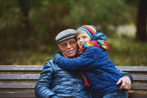 Εγγονός με παππού με μια βόλτα στο πάρκο φθινόπωρο  - Φωτογραφία, εικόνα