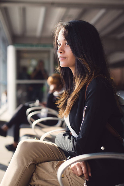 vrouw zit op de luchthaven en wachten op vliegtuig - Foto, afbeelding