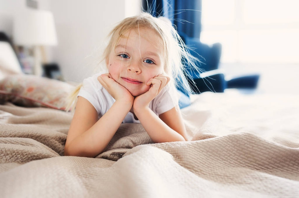cute happy toddler girl sitting on bed in pajama. Child playing at home, casual lifestyle capture. - Foto, Imagem