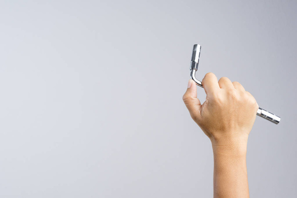 Ruka držící kovové víčko nebo ring klíč na bílém pozadí - Fotografie, Obrázek
