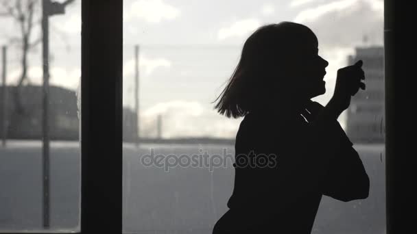 Bir pencere önünde dans bir kız silüeti - Video, Çekim