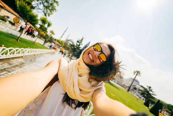 Feliz viajante menina feliz faz selfie, um muçulmano com óculos, um estudante de intercâmbio
 - Foto, Imagem