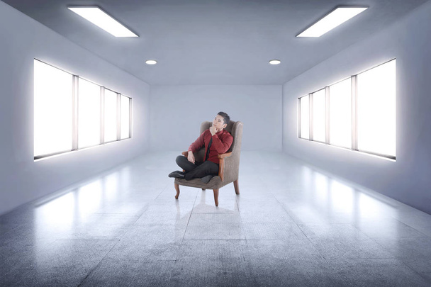 Handsome asian businessman sitting on an armchair and thinking a - Фото, зображення