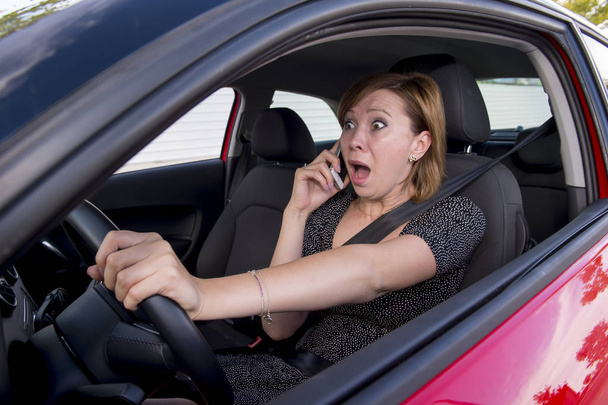 piękna kobieta jazdy samochodem podczas pisania wiadomości SMS przy użyciu telefonu komórkowego rozproszony - Zdjęcie, obraz