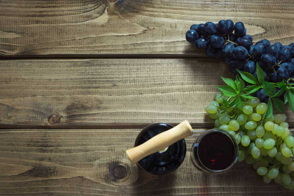 Açık bir şişe kırmızı şarap cam, tirbuşon ve ahşap bir gemide olgun üzüm ile. Kopya alanı ve üstten görünüm. - Fotoğraf, Görsel