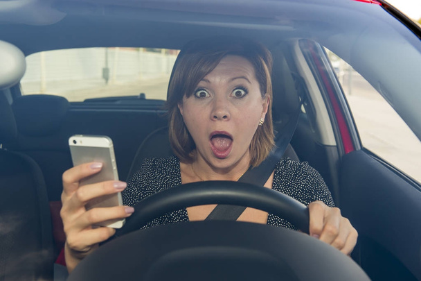 美しい女性の気を取らの携帯電話を使用して携帯メールしながら車を運転して - 写真・画像