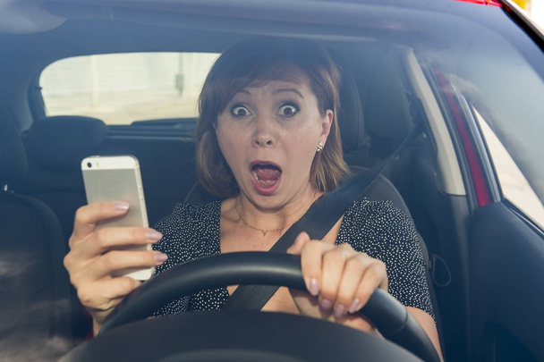 szép nő, miközben SMS használ mozgatható telefon zavart autó vezetés - Fotó, kép