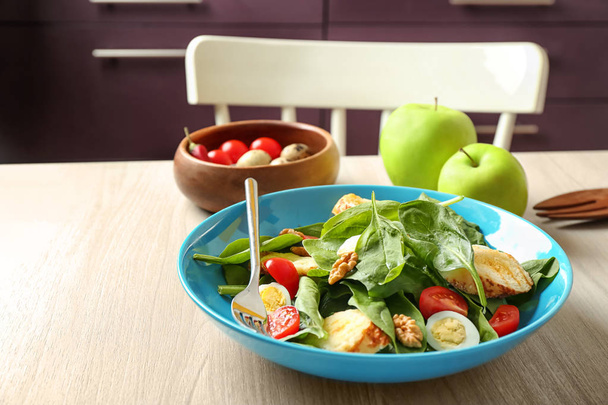 Plate of tasty salad with spinach leaves  on wooden table - Foto, Imagen