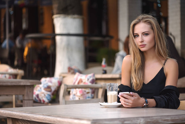 menina com café e telefone sentado em um café
 - Foto, Imagem