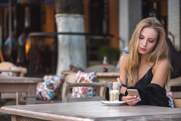 girl with phone and coffee in a cafe - Photo, Image