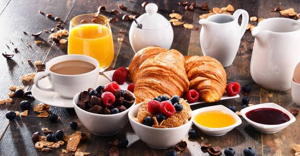 Breakfast served with coffee, juice, croissants and fruits - Photo, Image