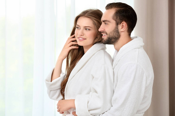 Young loving couple in bathrobes  - Fotó, kép