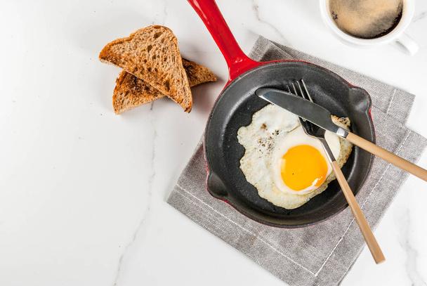 Café da manhã com pão torrado, ovo frito na panela de ferro e café o
 - Foto, Imagem