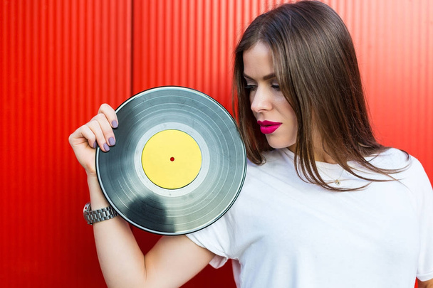 Woman holding a vinyl record - Foto, afbeelding