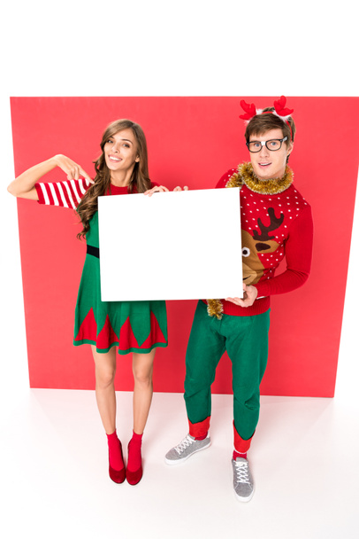pareja en trajes de Navidad con pancarta
 - Foto, imagen