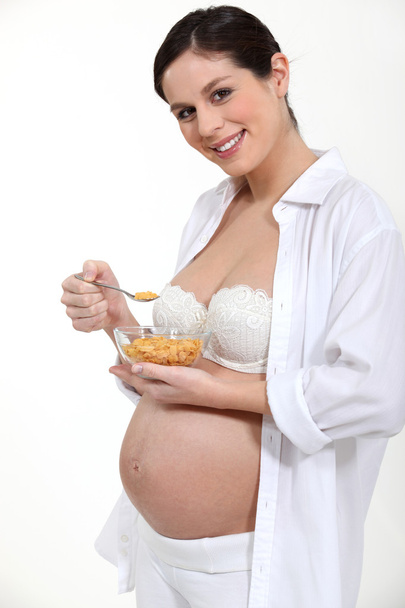 Pregnant woman eating cereal - Fotoğraf, Görsel