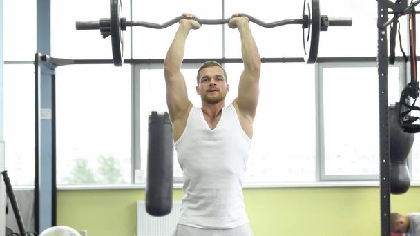 Muskularny mężczyzna na trening siłowy w siłowni. Sportowiec sprawia, że triceps ćwiczenia ze sztangą - Zdjęcie, obraz