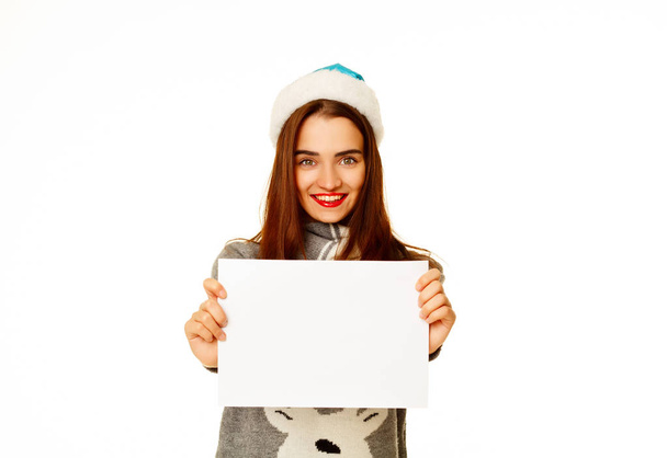 Young happy woman in  warm sweather with empty paper over white  - Foto, Imagen