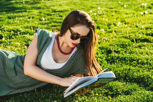 Reading woman on grass.Preparing student in park,sun glasses - Fotoğraf, Görsel