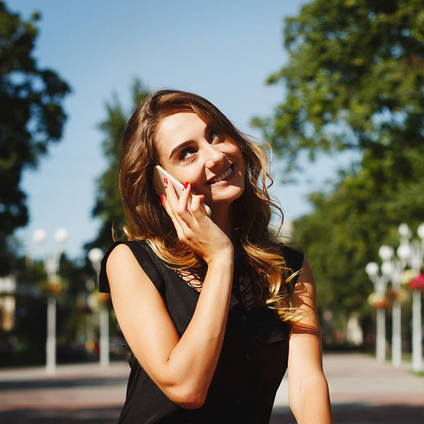 Portrait of a beautiful young happy woman talking by smart phone - Valokuva, kuva