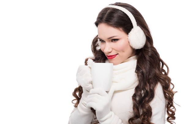 nő a téli fülvédő iszik, bögre - Fotó, kép
