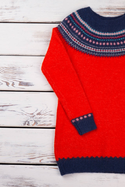 Червоний светр на дерев'яному фоні
. - Фото, зображення
