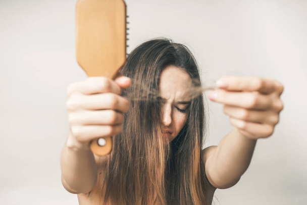 Hairs lost,woman with comb, long hair, angry girl - Foto, afbeelding