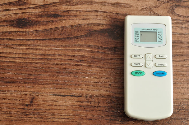 An air conditioners remote isolated on a wooden background - Photo, Image