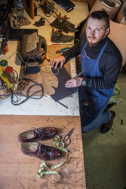 Работает обувщик-мужчина  - Фото, изображение