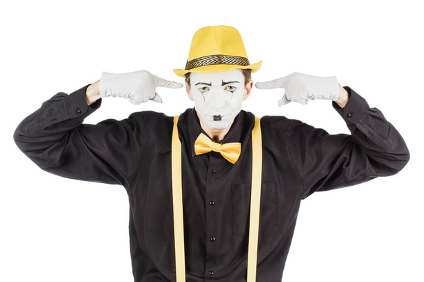 Молодой актер, пантомима, закрывает руки за ушами, он
 - Фото, изображение