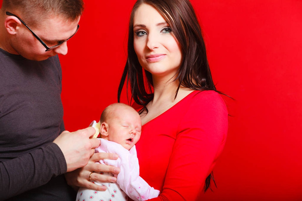 Neugeborenes auf der Brust der Mutter, Vater bürstet Babyhaare - Foto, Bild