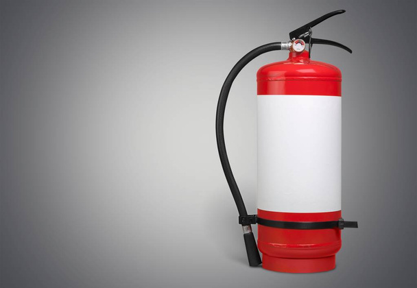 Red Fire extinguisher on light wall background  - Fotó, kép