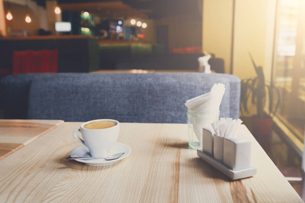 Современный интерьер ресторана, чашка кофе на столе
 - Фото, изображение