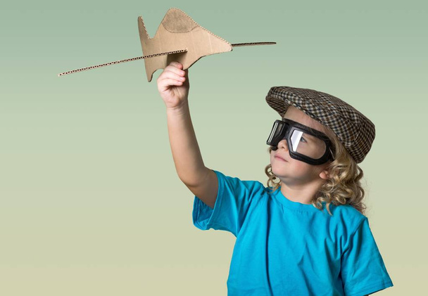 kleine jongen met houten vliegtuig - Foto, afbeelding