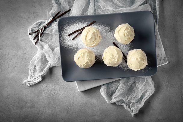 Tasty vanilla cupcakes on plate - Фото, зображення