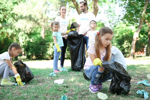 Young volunteers and children collecting garbage in park - Fotografie, Obrázek