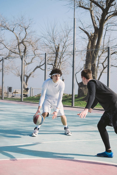 Two basketball player playing basketball outdoors - Foto, Imagem