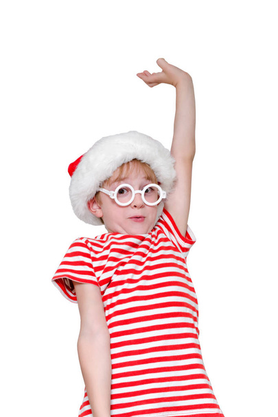 Niño en un sombrero de Santa con una cara asombrada y una mano levantada
 - Foto, imagen