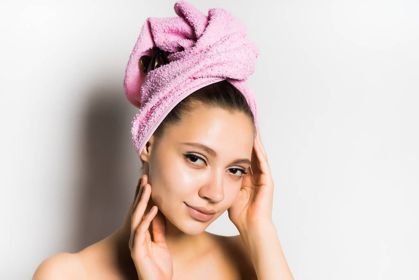 girl with a towel on her head feels the contours of her face - Foto, Bild