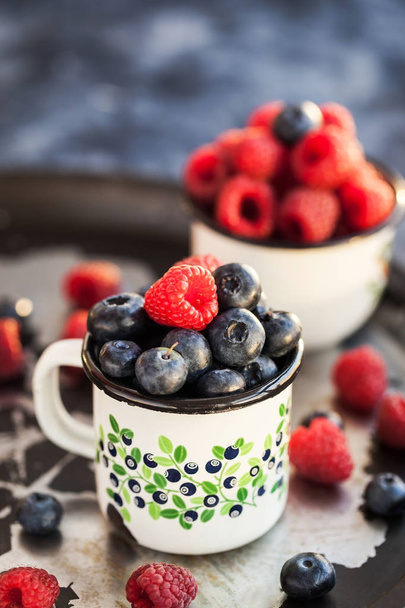 Fresh ripe blueberry and raspberry in mugs  - Zdjęcie, obraz