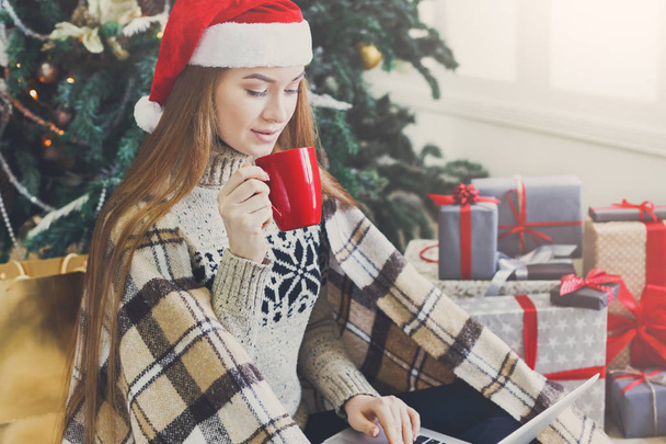 Young woman shopping online in cozy christmas interior - Photo, Image