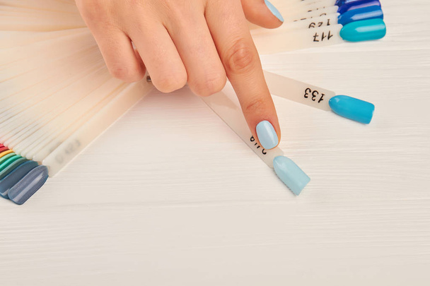 Index finger choosing color on nail palette. - Photo, Image