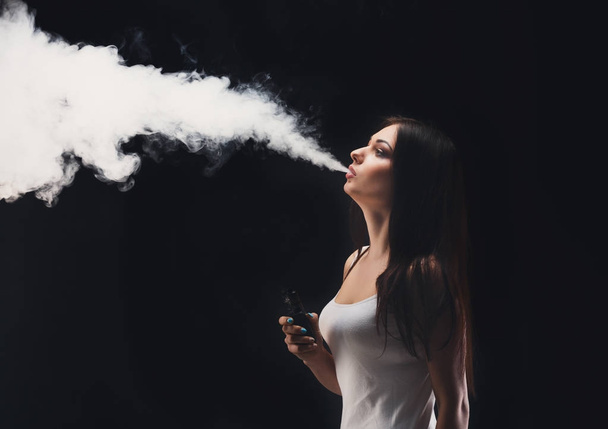 Genç kadın vaping e-sigara dumanlı siyah - Fotoğraf, Görsel