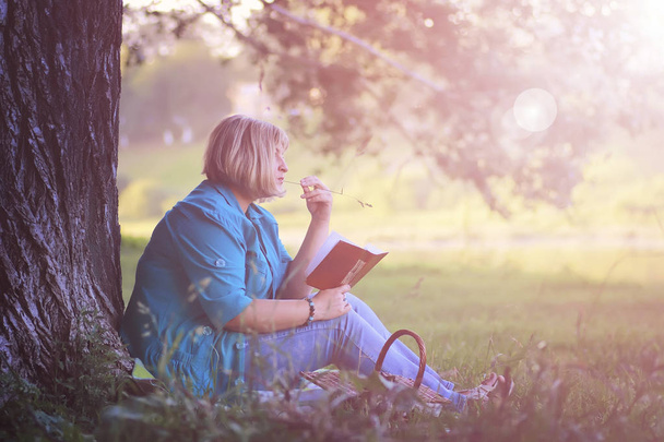 kadın parkta günbatımı kitap ile - Fotoğraf, Görsel