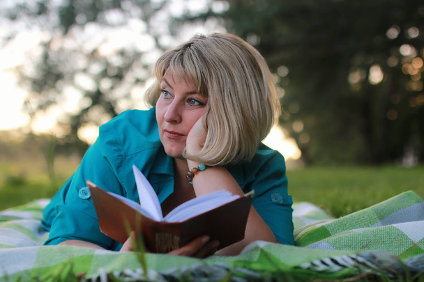 Frau im Park mit Buch im Gras - Foto, Bild