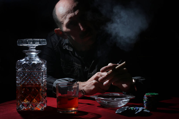 hombre pipa de humo y jugar al poker
 - Foto, Imagen