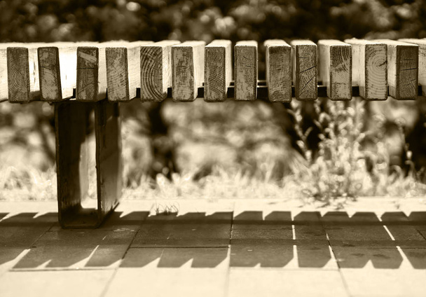 Horizontal sepia park bench bokeh background - Foto, Imagen