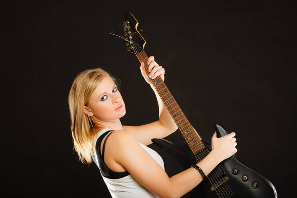 Mujer rubia sosteniendo la guitarra eléctrica, fondo negro
 - Foto, Imagen